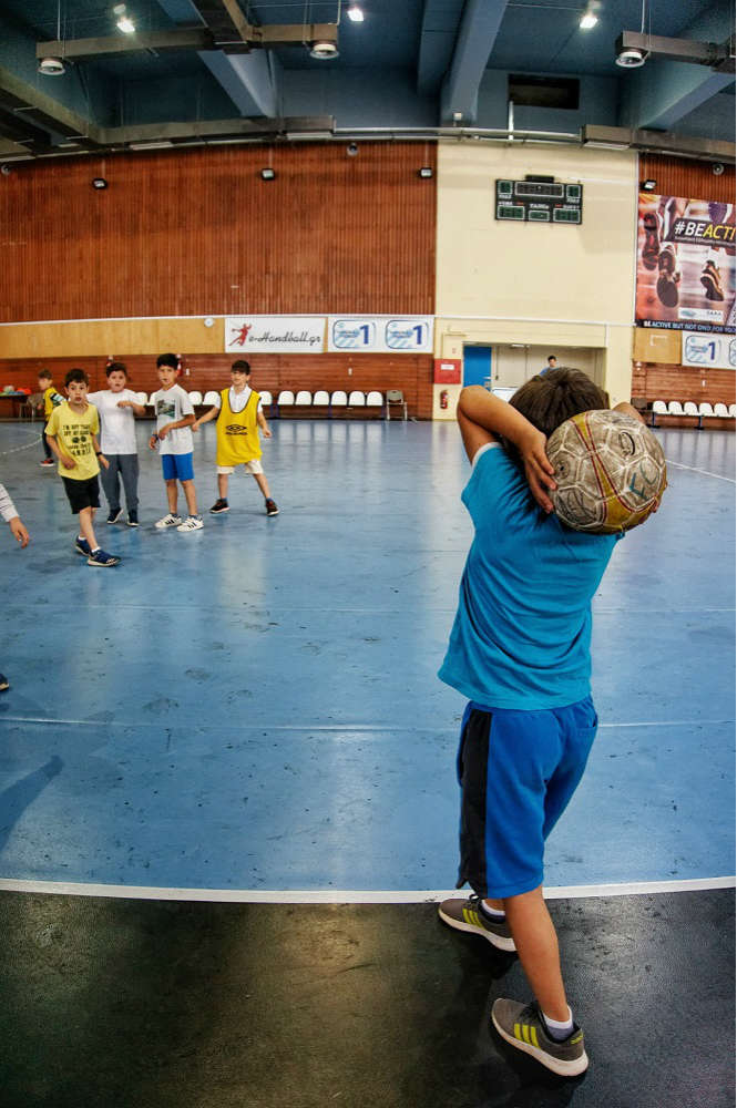 τα παιδιά που συμμετέχουν στο summer camp ο πρωταθλητής παίζουν ποδόσφαιρο σε κλειστή αίθουσα